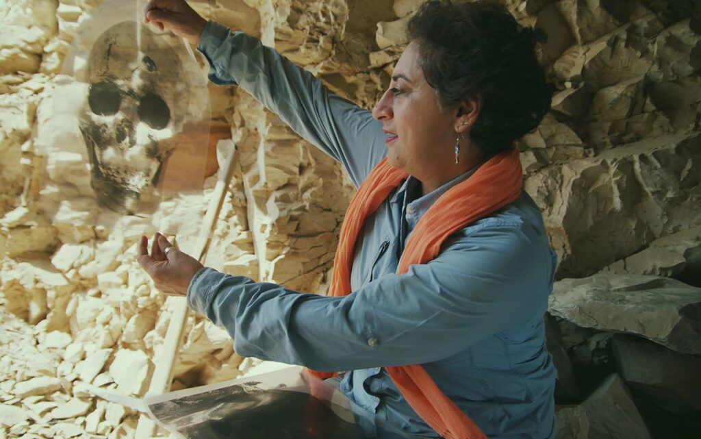 Archaeologist Salima Ikram examines an image of a skull from the mass burial.