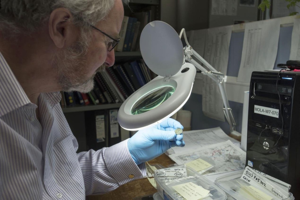 Dr Julian Bowsher examines the rare coin.