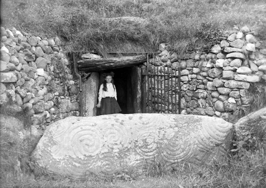 A young girl stands in front of the entrance to Newgrange in about 1905