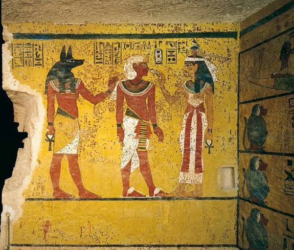 A fresco on the wall of his tomb shows Tutankhamun with the god Osiris