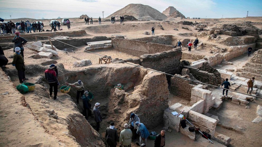 Workers excavate a site during the official announcement of the discovery by an Egyptian archaeological mission of a new trove of treasures at Egypt's Saqqara necropolis south of Cairo, Egypt, Jan. 17, 2021.